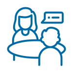 Das Bild zeigt zwei Personen, die etwas an einem Tisch besprechen.