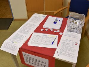 Das Bild zeigt einen Tisch mit Blättern, die man unterschreiben kann.