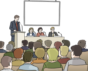 Auf dem Bild halten mehrere Personen vorne eine Rede oder sprechen auf einer Veranstaltung – viele Menschen hören zu.