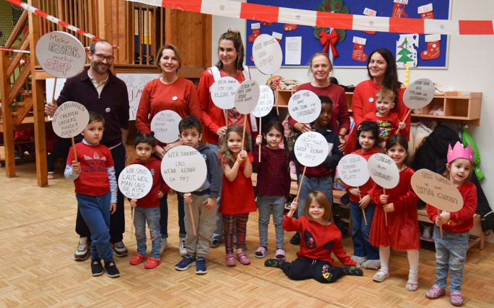 Auf dem Bild sieht man Kinder under Erwachsene mit Schildern in den Händen.