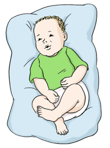 Das Bild zeigt ein Baby, das auf einem Kissen liegt.