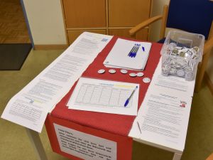 Das Bild zeigt einen Tisch mit Blättern, die man unterschreiben kann.