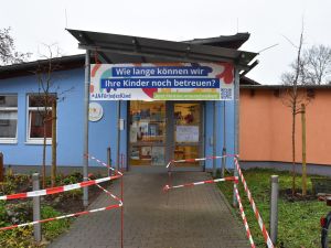 Das Bild zeigt dein Eingang der Tom-Mutters-Kindertagesstätte mit einem bunten Banner.